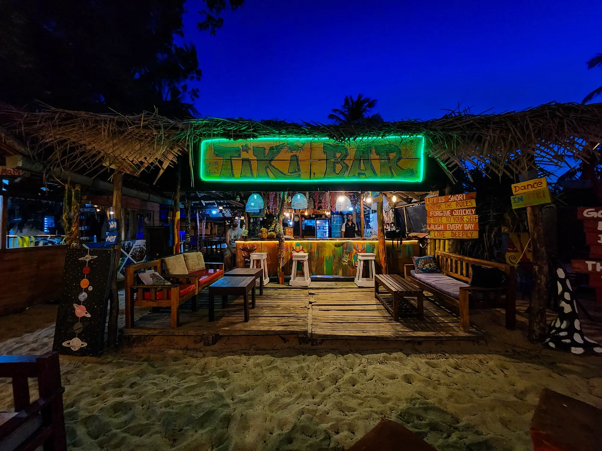 Tiki beach bar photographed under a deep blue night sky