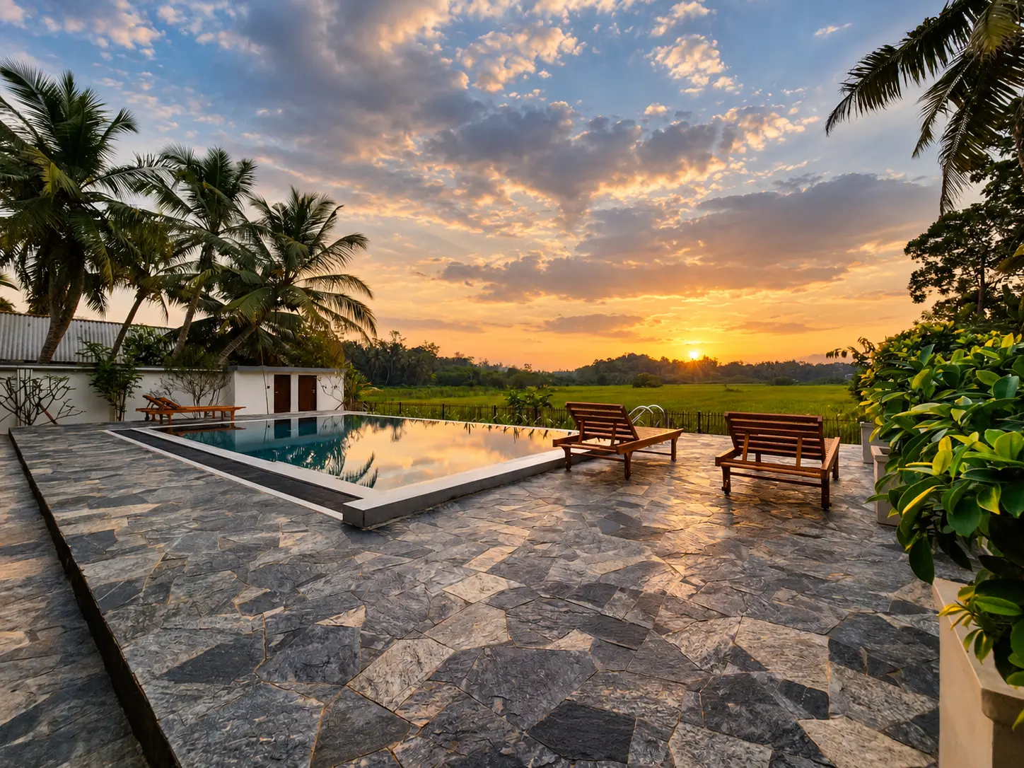Swimming pool at sunset with tropical landscape